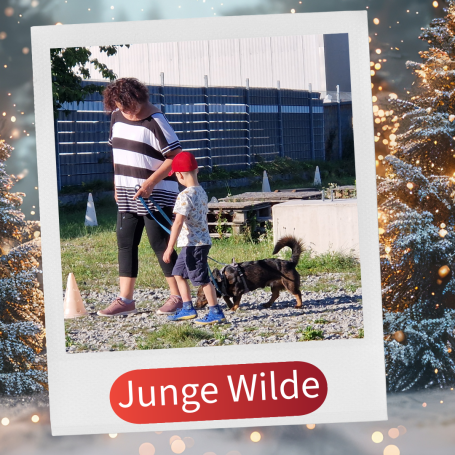 Ein Junge mit einem Hund und einer Frau auf einem Trainingsplatz.